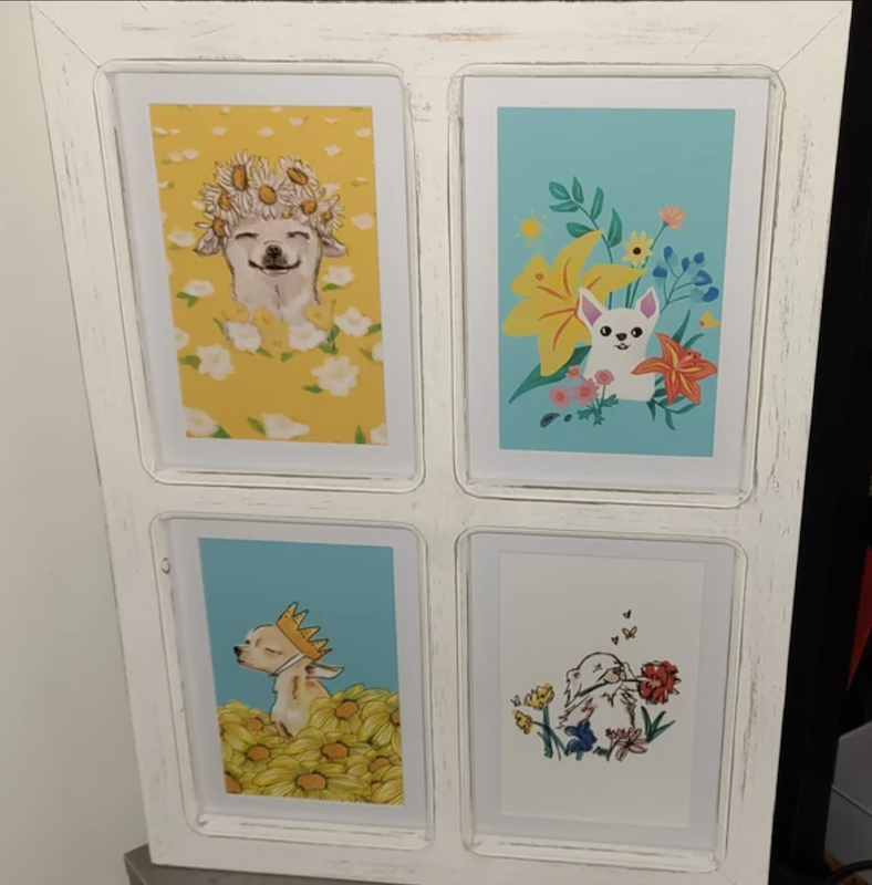 a photo of four framed chihuahua paintings of small dogs in fields of flowers